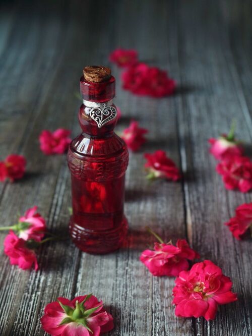 love potion red bottle surrounded by pink flowers