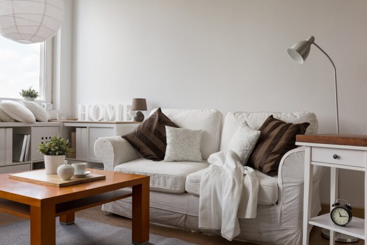 cozy living room with a white sofa and brown throw pillows
