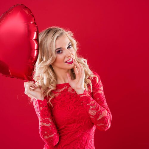 a girl in a red dress holding a heart