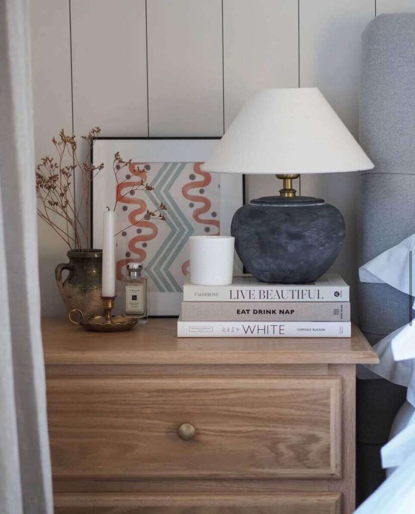 bedside table decor with books and a lamp.